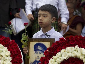 A boy holds a portrait of Gen. Aung San during a ceremony marking the 30th anniversary of the pro-democracy uprising, Wednesday, Aug. 8, 2018, in Yangon, Myanmar. August 8 marks the 30th anniversary of the nation-wide protests for democracy against the then military dictatorship. The protest was referred to as 8-8-88 (four eights) uprising- in which more than a million people took to the streets. The military government took power in Sept. 1988 after crushing the democracy movement killing several hundred.
