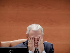 FILE- In this Wednesday, June 21, 2017, file photo, the head of the Ruling Social Democratic Party, Liviu Dragnea wipes his eyes at the Romanian parliament in Bucharest, Romania. Claims by the leader of Romania's ruling party that he was the target of a failed assassination attempt have sparked wide debate in the country after Liviu Dragnea told a television station late Tuesday, Aug. 21, that 4 foreigners had come to Bucharest for the April 2017 assignment, but had been thwarted.