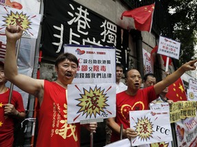 Pro-China protesters shout slogans against pro-independence activist Andy Chan as he delivers a controversial speech at Foreign Correspondents Club, Hong Kong, Tuesday, Aug. 14, 2018, despite China's Foreign Ministry's request to cancel the talk.