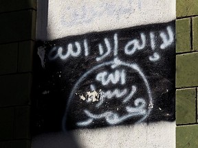 The black al-Qaida flag is sprayed on the wall of a damaged school that was turned into a religious court, in Taiz, Yemen, shown in this Oct. 16, 2017, photo.