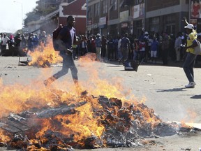 Opposition MDC party supporters protest in the streets of Harare during clashes with police Wednesday, Aug. 1, 2018.