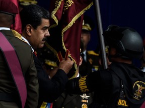 Venezuelan President Nicolas Maduro (L) at a ceremony to celebrate the 81st anniversary of the National Guard in Caracas on August 4, 2018. The event was cut short after a drone exploded near where Maduro was speaking.