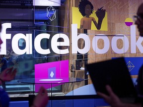 In this April 18, 2017, file photo, conference workers speak in front of a demo booth at Facebook's annual F8 developer conference, in San Jose, Calif.