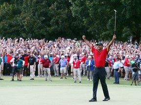 Tiger Woods celebrates making a par on the 18th green to win the Tour Championship at East Lake Golf Club on September 23, 2018 in Atlanta, Georgia.