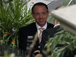 U.S. Deputy Attorney General Rod Rosenstein talks to an unidentified man as he arrives at the White House September 27, 2018 in Washington, DC.