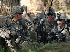 U.S. Army 1Lt. Scott Doyle (L) moves soldiers into position while under fire on March 16, 2010 at Howz-e-Madad in Kandahar province, Afghanistan.