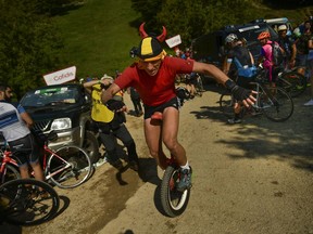 A Spain La Vuelta cyclist fan uses a unicycle near the finish line of the 14th stage between Cistierna and Les Praeres Nava, 171 kilometers (106,25 miles), of the Spanish Vuelta cycling race that finishes in Les Praeres Nava, northern Spain, Saturday, Sept. 8, 2018.