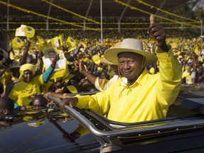 FILE - In this Tuesday, Feb. 16, 2016 file photo, Uganda's long-time President Yoweri Museveni waves to supporters from the sunroof of his vehicle as he arrives for an election rally at Kololo Airstrip in Kampala, Uganda. Museveni who at 74 is one of Africa's longest-serving presidents, faces a serious threat from a crusading pop star-turned-lawmaker who is rallying young people in Uganda and beyond frustrated by aging leaders they say are out of touch.