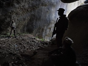 This photo taken on April 26, 2018 shows Pakistani soldiers standing guard at the site of the seventh-century rock sculpture of a seated Buddha carved into a mountain in Jahanabad town in the northwestern Swat Valley of Pakistan, following a restoration process conducted by Italian archaeologists after the Taliban defaced it in 2007.