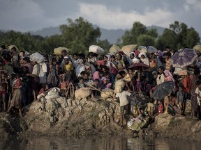 This file photo taken on Oct.10, 2017, shows Rohingya refugees fleeing from Myanmar arriving at the Naf river in Whaikyang on the Bangladesh border.