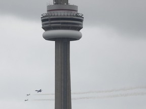 A CF-18 fighter jet and two Snowbirds fly around he downtown core and around the CN Tower in preparation for the 69th annual Canadian International Air Show which runs Saturday, Sunday Monday of the Labour Day weekend on Thursday August 30, 2018.