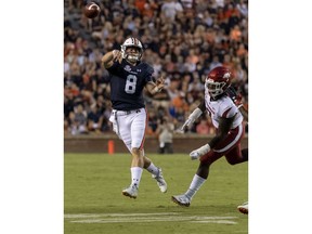 Auburn quarterback Jarrett Stidham (8) throws on the run with Arkansas defensive lineman Briston Guidry (7) in pursuit during the first half of an NCAA college football game, Saturday, Sept. 22, 2018, in Auburn, Ala.