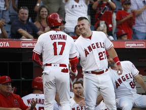 Los Angeles Angels' Shohei Ohtani shakes hands with Mike Trout after hitting a home run during the first inning of a baseball game against the Seattle Mariners, Saturday, Sept. 15, 2018, in Anaheim, Calif.