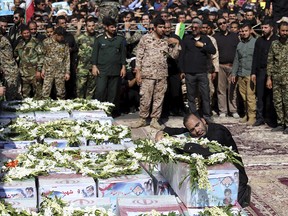 Father of Mohammad Taha Eghadami, a 4-year-old boy who was killed in Saturday's terror attack on a military parade, mourns over his coffin during a mass funeral ceremony for the victims, in southwestern city of Ahvaz, Iran, Monday, Sept. 24, 2018.