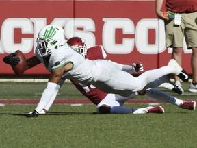 North Texas receiver Jalen Guyton makes a catch in front of Arkansas defender Nate Dalton in the first half of an NCAA college football game Saturday, Sept. 15, 2018, in Fayetteville, Ark.