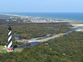 FILE - This 2003, file photo, shows the Cape Hatteras Lighthouse overlooking the Atlantic Ocean and the village of Buxton, N.C. Hurricane Florence has become a reminder of how vulnerable North Carolina's coast is. Experts said Tuesday, Sept. 11, 2018, that the storm could be the state's most destructive on record.