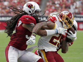 Washington Redskins running back Chris Thompson, center, is hit by Arizona Cardinals defensive back Tre Boston, left, during the first half of an NFL football game, Sunday, Sept. 9, 2018, in Glendale, Ariz.