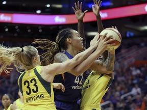Phoenix Mercury center Brittney Griner (42) is guarded by Seattle Storm's Sami Whitcomb (33) and Natasha Howard as she tries to drive to the basket during the first half of Game 4 of a WNBA basketball semifinals playoff game, Sunday, Sept. 2, 2018, in Phoenix.