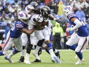 Buffalo Bills linebacker Tremaine Edmunds (49) hangs onto Baltimore Ravens running back Alex Collins (34) who carries the ball toward the end zone for a touchdown during the first half of an NFL football game Sunday, Sept. 9, 2018 in Baltimore.