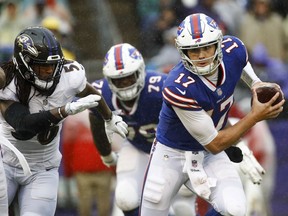 Buffalo Bills quarterback Josh Allen (17) scrambles away from Baltimore Ravens linebacker Tim Williams (56) with the ball during the second half of an NFL football game, Sunday, Sept. 9, 2018, in Baltimore.