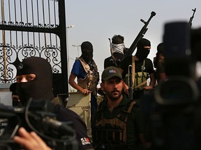 Popular Mobilization Forces parade in Basra, 340 miles (550 km) southeast of Baghdad, Iraq, Saturday, Sept. 8, 2018. A local military commander for an alliance of powerful Shiite militias, many of them backed by Iran, vowed a response Saturday to weeklong protests that have turned violent in the southern city of Basra, raising the specter for more escalation in the oil-rich southern region.