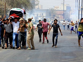 Mourners throw stones at government security forces during the funeral of Mekki Yasser, a protester whose family and activists said he was killed when he participated in a protest last night, on Tuesday, Sept. 4, 2018, in Basra, 340 miles (550 kilometers) southeast of Baghdad, Iraq.