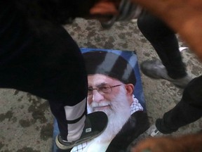 Protesters trample a portrait of Iran's supreme Leader Ayatollah Ali Khamenei, during the storming and burning the Iranian consulate in Basra, 340 miles (550 km) southeast of Baghdad, Iraq, Friday, Sept. 7, 2018. Hundreds of angry protesters in Basra took to the streets on Thursday night. Some clashed with security forces, lobbing Molotov cocktails and setting fire to a government building as well as the offices of Shiite militias. At least three people were shot dead in confrontations with security forces.