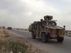 This frame grab from video provided by Central Station for Turkish Intervention, an activist-operated media group monitoring Turkish activities in Syria, that is consistent with independent AP reporting, shows a Turkish military convoy heading to some of the 12 Turkish observations points that ring Idlib, Syria, Thursday, Sept. 13, 2018. Turkey sent in military reinforcements Thursday to beef up its positions inside Syria's last rebel bastion Idlib, activists reported, even as the Turkish defense minister said Ankara is still trying with Russia and Iran to prevent a humanitarian tragedy in the case of a threatened Syrian government offensive. (Central Station for Turkish Intervention, via AP)