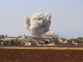 This photo released on Monday, Sept. 10, 2018 by the Syrian Civil Defense group known as the White Helmets, shows smoke rising from a Syrian government airstrike, in Hobeit village, near Idlib, Syria. High-level diplomats from Iran, Russia and Turkey were meeting Tuesday with the U.N. envoy for Syria about creating a committee to revise the war-battered country's constitution. Tuesday's talks in Geneva under U.N. envoy Staffan de Mistura come amid concerns he and other U.N. officials have expressed about a looming battle for Idlib. (Syrian Civil Defense White Helmets via AP)