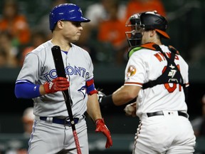 Toronto Blue Jays' Aledmys Diaz, left, walks off the field after striking out swinging next to Orioles catcher Austin Wynns during the second inning of their game Wednesday night in Baltimore. The Orioles won 2-1.