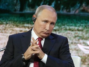 Russian President Vladimir Putin listens via an earpiece during day two of the Eastern Economic Forum in Vladivostok, Russia, on Sept. 12, 2018.