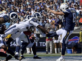 Los Angeles Rams linebacker Cory Littleton blocks a punt by Los Angeles Chargers punter Drew Kaser in the end zone during the first half in an NFL football game Sunday, Sept. 23, 2018, in Los Angeles.