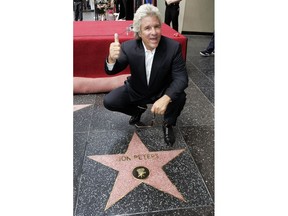 FILE - In this May 1, 2007 file photo, Hollywood producer Jon Peters poses with his new star on the Hollywood Walk of Fame during dedication ceremonies in Los Angeles. Peters is a credited producer of the new "A Star Is Born," the third remake of the Hollywood fable. But with the new film in the spotlight, Peters' history has come under scrutiny. Warner Bros. on Tuesday, Sept. 11, 2018, said the studio was contractually obligated to honor Peters as a producer.