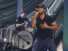 FILE - In this May 5, 2018 file photo, Luke Bryan performs at the iHeartCountry Festival at the Frank Erwin Center in Austin, Texas. Country singer and songwriter Bryan has hosted a free street concert to mark the opening of his new Tennessee restaurant that drew nearly 30,000 people to downtown Nashville. The Tennessean reports the concert on Monday, Sept. 10, 2018, marked the grand opening earlier that afternoon of Luke's 32 Bridge Food + Drink, a multi-story live entertainment complex.