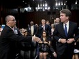 FILE - In this Tuesday, Sept. 4, 2018 file photo, Fred Guttenberg, the father of Jamie Guttenberg who was killed in the Stoneman Douglas High School shooting in Parkland, Fla., left, attempts to shake hands with President Donald Trump's Supreme Court nominee, Brett Kavanaugh, right, as he leaves for a lunch break while appearing before the Senate Judiciary Committee on Capitol Hill in Washington to begin his confirmation hearing. Kavanaugh did not shake his hand. Kavanaugh wrote in a response to questions from senators late Wednesday, Sept. 12, 2018, that he assumed the man had been a protester.