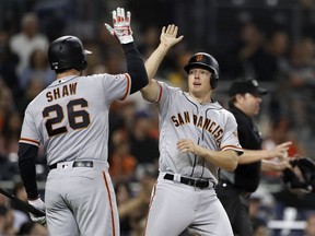 San Francisco Giants' Nick Hundley, right, reacts with teammate Chris Shaw (26) after scoring on a double by Hunter Pence during the fourth inning of a baseball game against the San Diego Padres on Tuesday, Sept. 18, 2018, in San Diego.