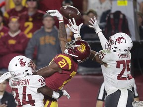 Southern California wide receiver Tyler Vaughns, center, misses a pass between Washington State safety Jalen Thompson, left, and safety Skyler Thomas during the first half of an NCAA college football game Friday, Sept. 21, 2018, in Los Angeles.