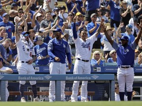 Los Angeles Dodgers players celebrate in the dugout as Max Muncy rounds the bases following a solo home run by Muncy against the Arizona Diamondbacks during the fifth inning of a baseball game Sunday, Sept. 2, 2018, in Los Angeles.