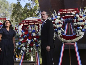 Paris Mayor Anne Hidalgo and Los Angeles Mayor Eric Garcetti pose with wreaths during a ceremony marking the 17th anniversary of the Sept. 11, 2001 terrorist attacks on the United States, at the Los Angeles Fire Department's training center Tuesday, Sept. 11, 2018. In the right background is the largest fragment of the World Trade Center outside New York.