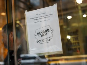 A sign on the door of a downtown Toronto A&W restaurant explaining they have no more Beyond Meat burgers at this location.