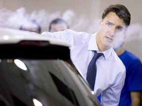 Prime Minister Justin Trudeau uses a smoke wand during a demonstration of air flow over a car during a visit to the University of Ontario's Institute of Technology in Oshawa, Ont. on Friday August 31, 2018.