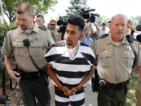 FILE - In this Aug. 22, 2018, file photo, Cristhian Bahena Rivera is escorted into the Poweshiek County Courthouse for his initial court appearance in Montezuma, Iowa. Rivera is charged with first-degree murder in the death of Iowa college student Mollie Tibbetts, who disappeared July 18 from Brooklyn, Iowa. The Mexican national was known by another name on the dairy farm where he worked for the last four years: John Budd. It was confirmed by three people with knowledge of his employment history, who spoke on condition of anonymity.