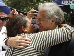 Organization of American States Secretary-General Luis Almagro, right, embraces a Venezuelan migrant at the "Divina Providencia" migrant shelter, in La Parada, Colombia, Friday, Sept. 14, 2018. Almagro visit Colombia's border with Venezuela to monitor the situation of migrants who have been fleeing the socialist-run country amid hyperinflation and widespread shortages and widespread shortages.