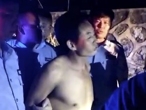 In this Wednesday, Sept. 12, 2018, image made from video, a suspect is arrested by policemen after he allegedly drove an SUV deliberately into a crowd in Hengyang in south China's Hunan province.