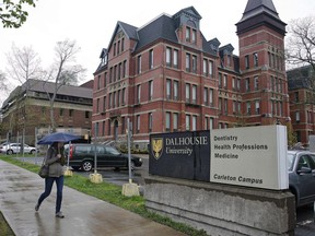 A pedestrian walks by the Dalhousie Dentistry Building in Halifax on May 22, 2015. A Canadian Cancer Society report says 65 university and college campuses across Canada are now fully smoke-free both indoors and out.The report says the number has more than doubled since last year, when 30 campuses were smoke-free. That's a dramatic rise from a decade earlier, when only four post-secondary institutions had full smoking bans.
