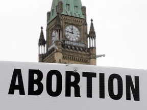 Pro-life supporters hold anti-abortion signs as they take part in the March For Life rally on Parliament Hill in Ottawa on Thursday, May 10, 2012.