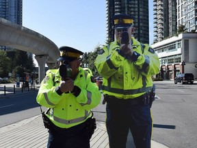 A Coquitlam RCMP officer, left, poses next to a life-sized, metal poster-board of an RCMP officer, in this undated handout photo. The newest recruit to the RCMP traffic section in Coquitlam, B.C., is a quiet fellow who won't be handing out tickets but the department hopes he'll have a big impact on speeding drivers.