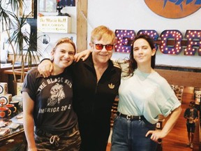 Elton John poses with Sonic Boom record store employees Lauren Mayer, left, and Ali Haberstroh in Toronto in this photo from Sonic Boom's twitter page. Elton John surprised employees at Toronto record shop Sonic Boom on Tuesday when he strolled into the store and bought a number of albums.
