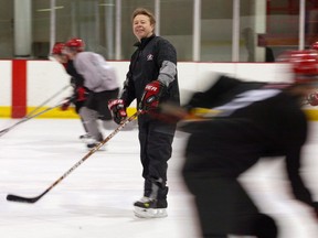 Team Canada head coach Stan Butler smiles as he watches a skating drill during team practice at the National Junior Team Selection Camp in Toronto on Wednesday Dec. 12, 2001.