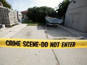 Yellow tape marks off access to a crime scene.  Authorities say three young men were shot to death in a White Castle on Detroit’s west side.